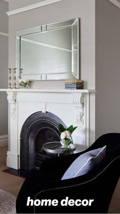 a living room filled with furniture and a mirror on top of a fireplace mantel