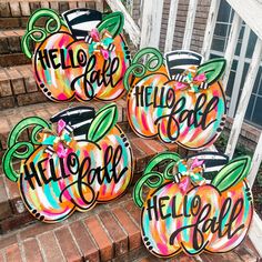 four painted pumpkins sitting on the steps with words hello fall and hello ball written on them