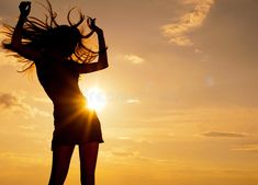 the silhouette of a woman with her hair blowing in the wind at sunset royalty photo