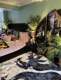 a bed room with a large mirror on the wall next to a table and plants