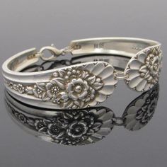 two silver bracelets with flowers on them