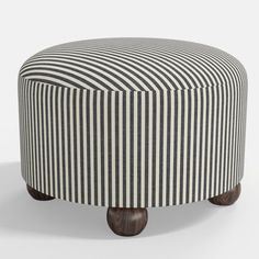 a black and white striped ottoman with wooden legs