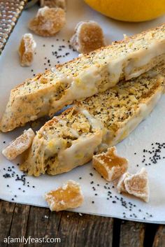 two pieces of bread sitting on top of a white plate next to an orange and some black seeds