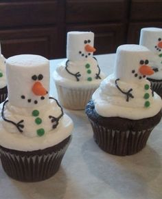 cupcakes made to look like snowmen with frosting on them