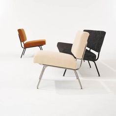 two chairs and a footstool sitting side by side on a white floor in an empty room