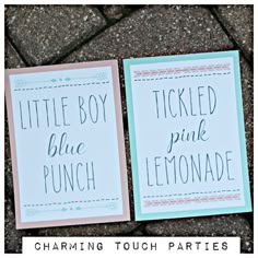 two little boy blue and pink lemonade signs sitting on the ground next to each other