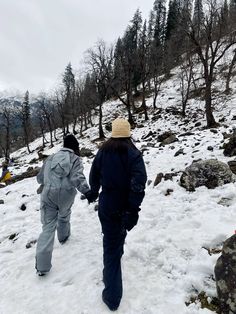 two people walking in the snow holding hands