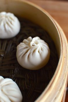 three dumplings are sitting in a basket on the table