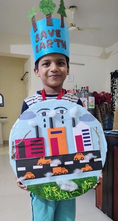 a young boy wearing a birthday hat and holding a paper plate