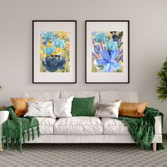 two paintings on the wall above a white couch