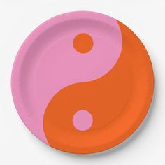 a paper plate with an orange and pink yin - yang symbol on it's side