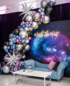 a living room filled with furniture and balloons in the shape of a star, surrounded by stars