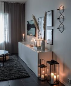 a living room with candles and pictures on the wall