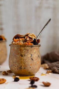 a bowl filled with oatmeal and raisins next to a spoon