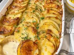 a casserole dish with potatoes and parmesan cheese on the side is ready to be eaten