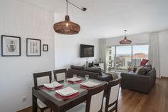 a dining room table with place settings on it in front of a large window overlooking the ocean