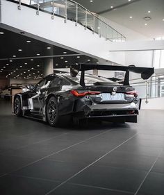 a black sports car parked in a large building