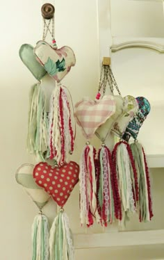 several hearts hanging from hooks on a wall