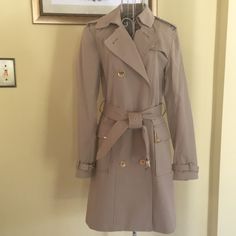 Michael Kors Woman’s Tan Trench Coat Size Small Removal Belt. Two Front Pockets With Gold Tone Accents. Length 35” Shoulder To Hem. Bust 17” Across One Side Pit To Pit. Waist 17” Across One Side. Doubled Breasted With Gold Tone Button Closure At Front. Excellent Condition Daughter Wore Once Or Twice. Smoke Free Home. Shipped Promptly. Price Is Firm Designer Gabardine Outerwear, Tailored Classic Michael Kors Outerwear, Classic Tailored Michael Kors Outerwear, Michael Kors Tailored Classic Outerwear, Michael Kors Classic Tailored Outerwear, Designer Beige Outerwear For Spring, Elegant Fitted Michael Kors Outerwear, Michael Kors Fitted Spring Outerwear, Michael Kors Classic Formal Outerwear