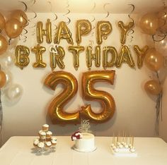 a white table topped with cake and balloons