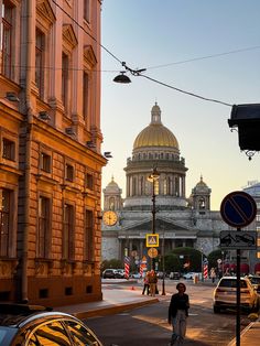 people are walking down the street in front of some buildings and a dome on top