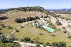 an aerial view of a large house in the middle of a field with trees and bushes