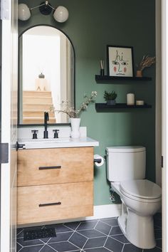 a bathroom with green walls and white fixtures