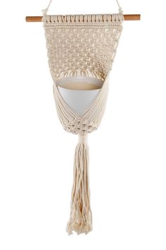 a macrame hanging on a wooden stick with a white bowl in the middle