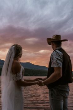 Newlyweds take in a romantic sunset over Lake McDonald following their Glacier National Park elopement. | Casual mountain elopement, cowboy wedding attire, eloping in Montana, casual groom's attire, Sydney Breann Photography