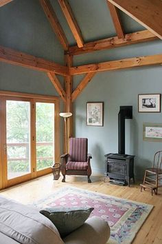 a living room filled with furniture and a wood burning stove in the middle of it