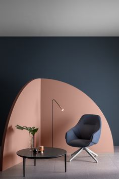 a chair and table in front of a wall with an arch shaped design on it