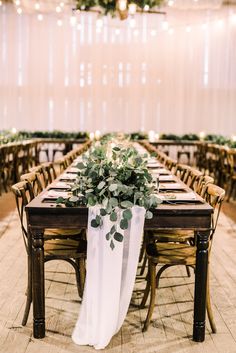 a long table with greenery on it