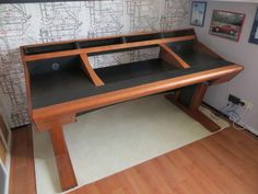 a wooden desk with two black trays on it's sides in front of a wall