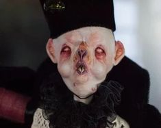 a creepy looking doll wearing a black hat