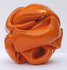 an orange sculpture sitting on top of a white table