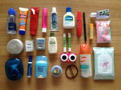 an assortment of personal care items laid out on a table top, including toothpaste, mouthwashes, eyeglasses, and more