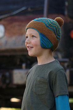 a young boy wearing a brown and blue hat