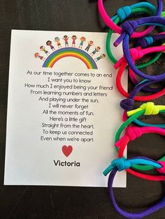 a rainbow bracelet with a poem written on it and some other colorful bracelets next to it