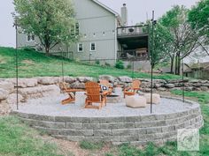 an outdoor fire pit with chairs around it