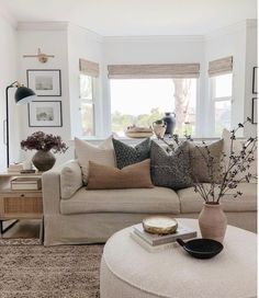 a living room filled with lots of furniture next to a large white couch and window