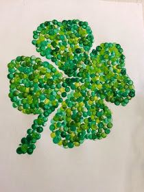 a drawing of a four leaf clover made out of green beads on white paper with scissors