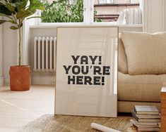 a poster with the words yay you're here on it in front of a couch