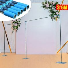 there are four blue pipes on the floor in front of a white wall with flowers