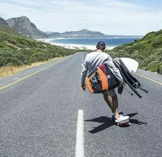 a man is walking down the road with his surfboard in hand and backpack on his back