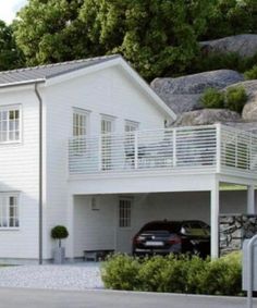 an image of a white house with cars parked in the driveway