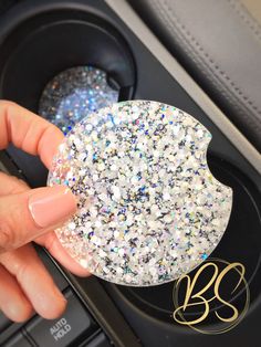 a person is holding a glitter covered object in their car's dash board holder