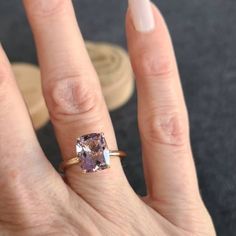 a close up of a person's hand with a ring on it and an amethyst