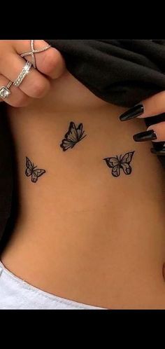 a woman's stomach with butterfly tattoos on her belly and the bottom part of her abdomen