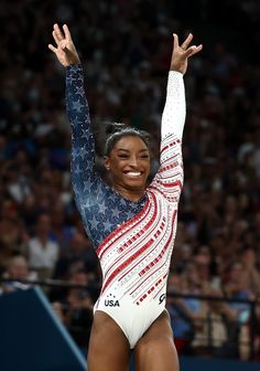 a woman in a gymnastics competition raising her arms