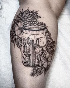 a black and white image of a cactus in a jar with flowers on it's thigh